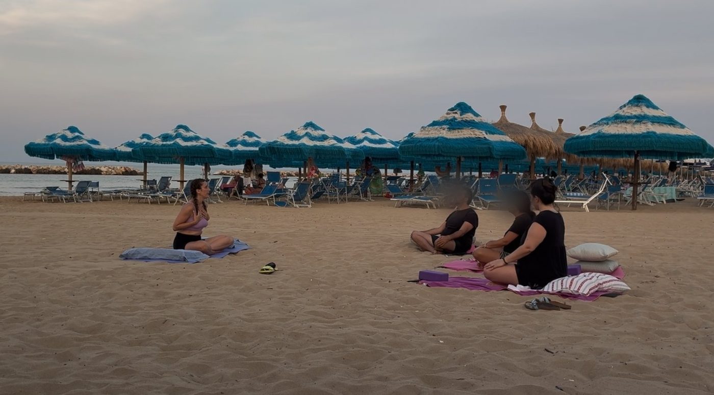 Federica Masci leading a group yoga class on the beach in Abruzzo at sunset